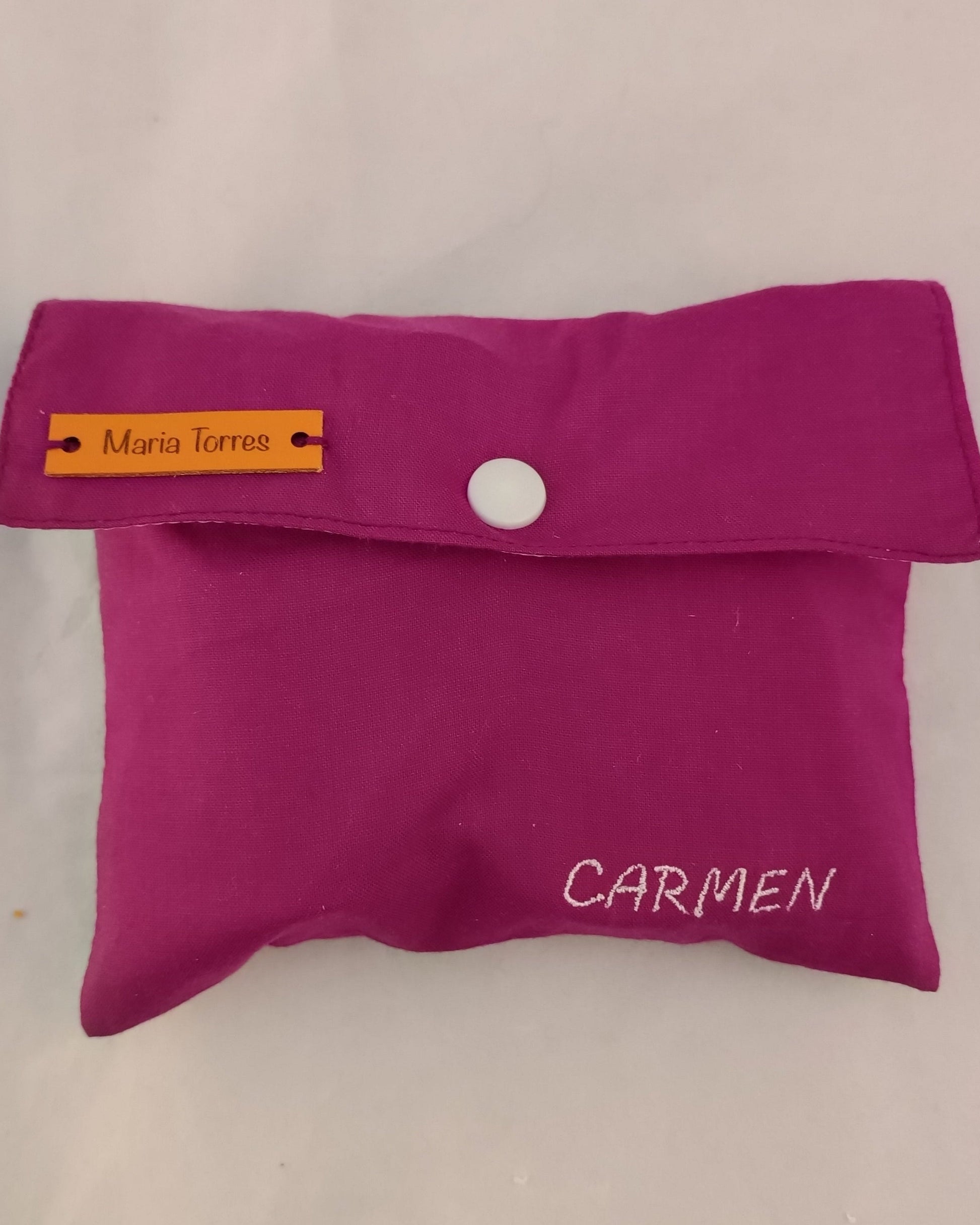 neceser de color morado con solapa y boton blanco, con nombre bordado 