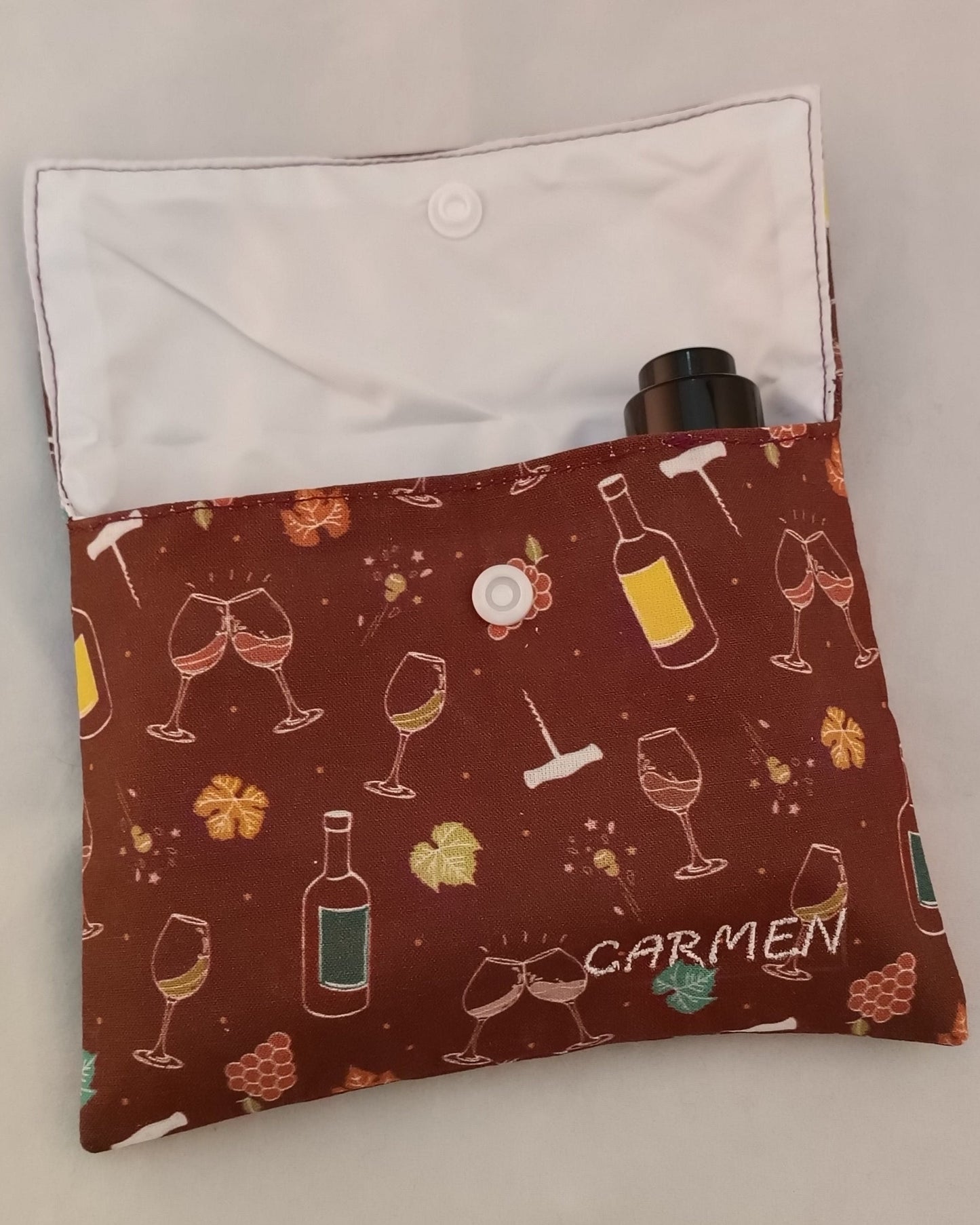 neceser de viaje con motivos de vino con solapa abierta en el que se ve la tapa de un serum dentro