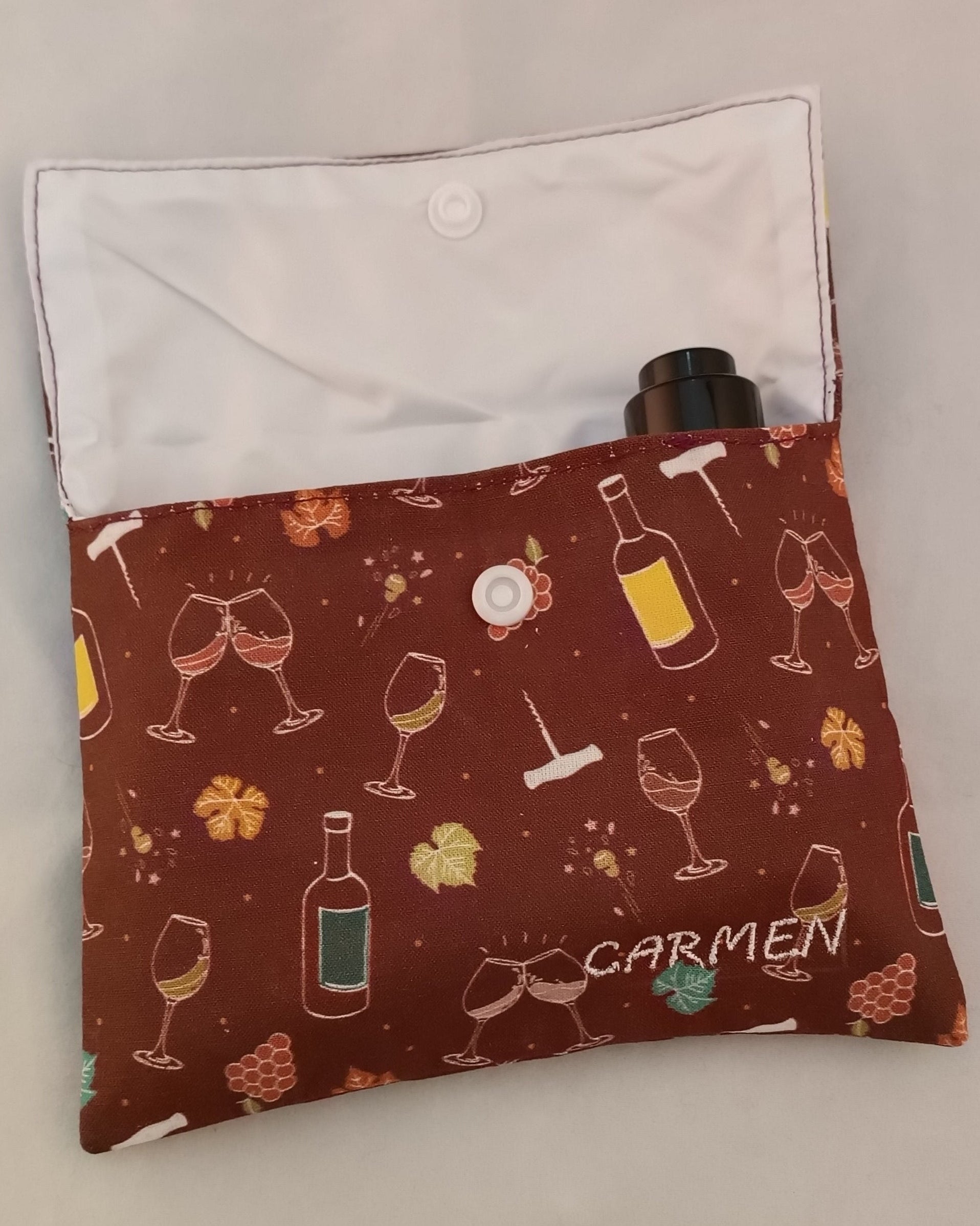 neceser de viaje con motivos de vino con solapa abierta en el que se ve la tapa de un serum dentro