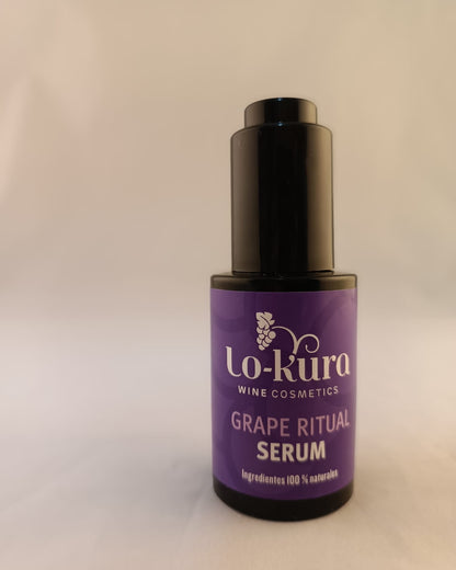 bote de cristal negro con aplicador negro de botón de serum con etiqiueta morada en la que se lee lo-kura wine cosmeetics grape ritual serum